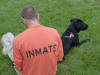 Inmate and dog taking a break in the grass.