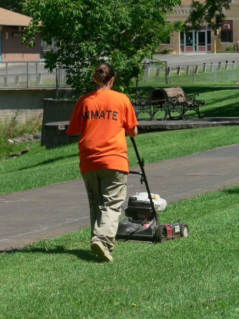 Female Inmate Mowing Lawn